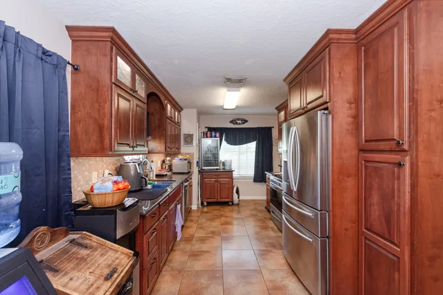 a kitchen with stainless steel appliances granite countertop a refrigerator and a stove