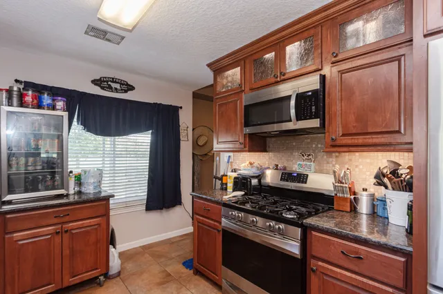a kitchen with stainless steel appliances granite countertop a stove and a microwave