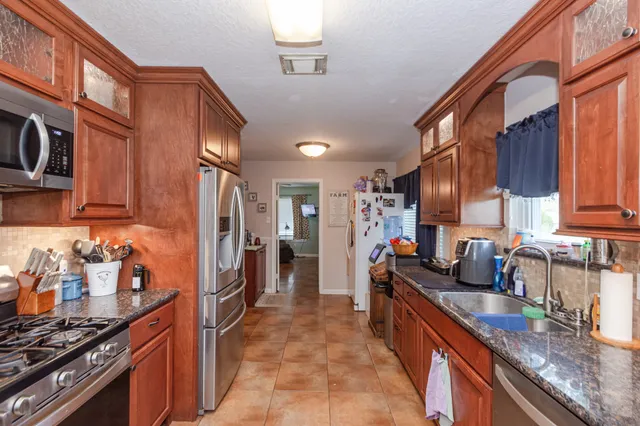 a kitchen with granite countertop a stove and a sink