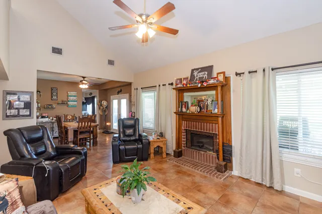 a living room with furniture a fireplace and a window