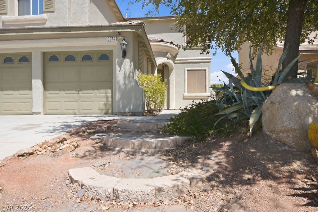 9712 North Running Rabbit Street Las Vegas, NV 89143 - Photo 12 of 42 A well-maintained stucco facade with a two-car garage and desert-friendly landscaping invites you home.