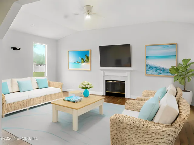 a living room with furniture a flat screen tv and a fireplace