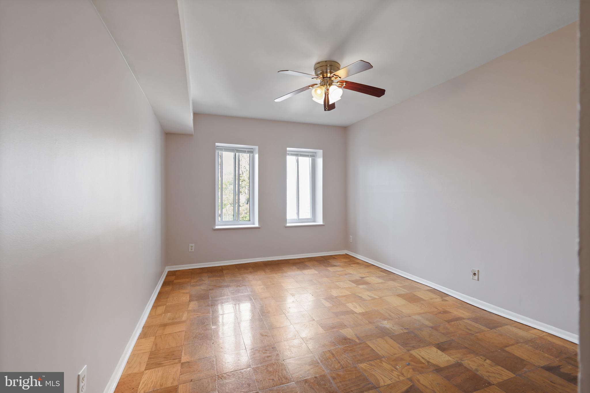 5050 7th Road South, Unit 301 Arlington, VA 22204 - Photo 14 of 20 an empty room with a chandelier fan and windows