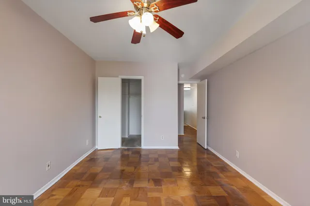 a view of an empty room with a chandelier fan