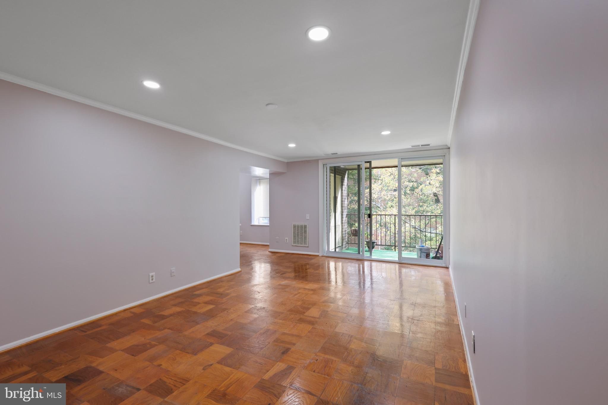 5050 7th Road South, Unit 301 Arlington, VA 22204 - Photo 4 of 20 a view of an empty room with wooden floor and a window