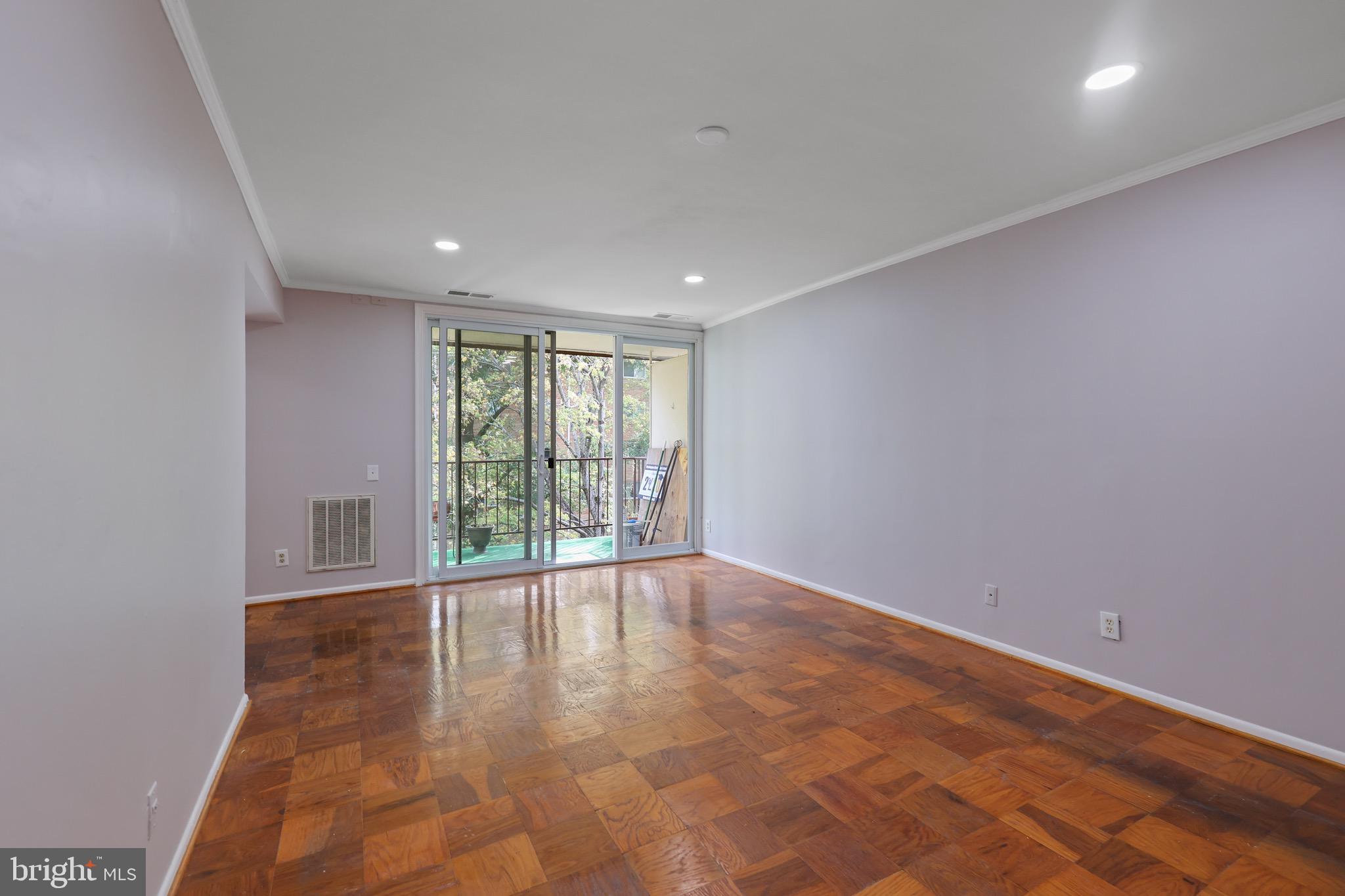 5050 7th Road South, Unit 301 Arlington, VA 22204 - Photo 5 of 20 a view of an empty room with wooden floor and a window
