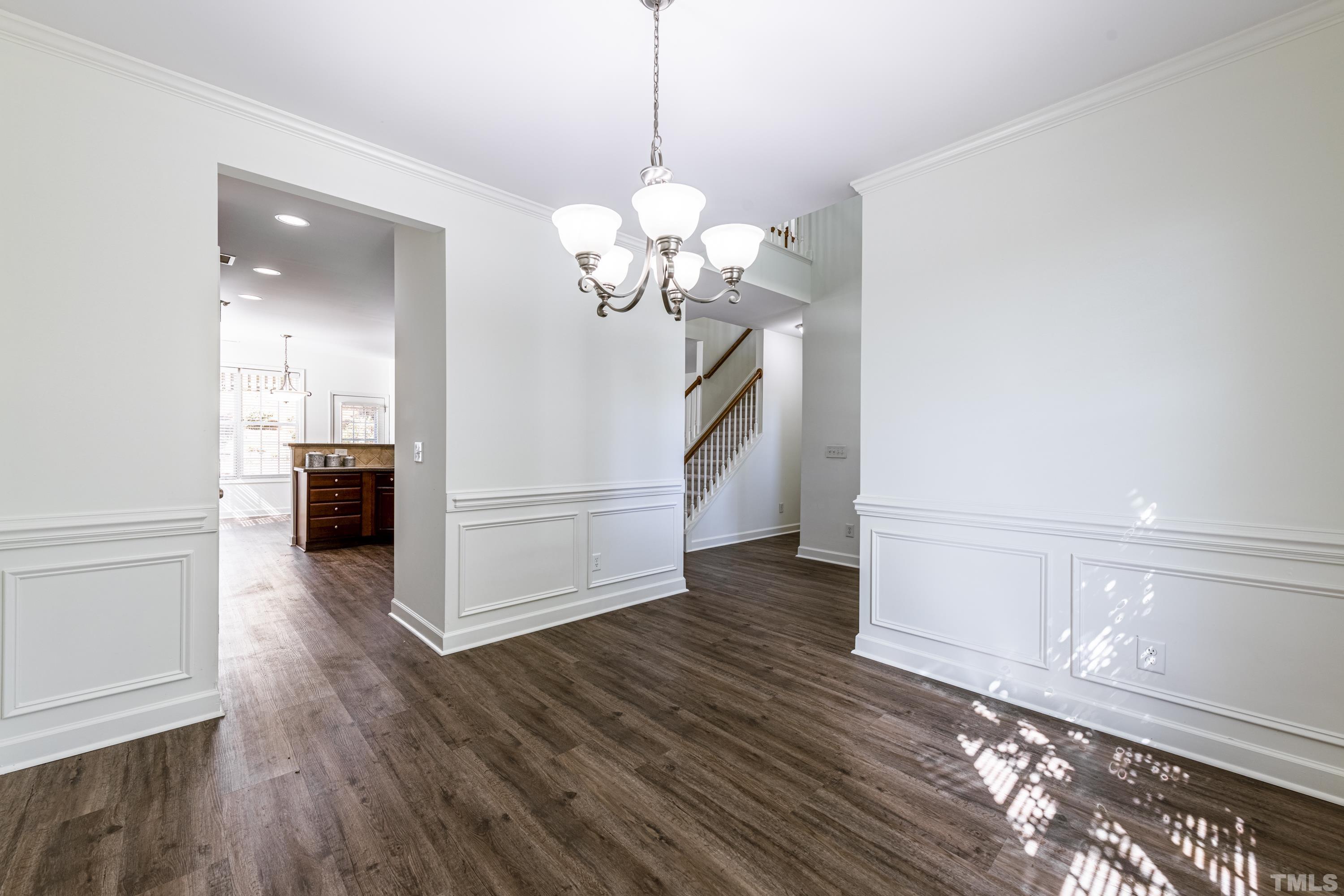 5217 Holly Ridge Farm Road Raleigh, NC 27616 - Photo 8 of 37 a view of a hallway with wooden floor and a chandelier
