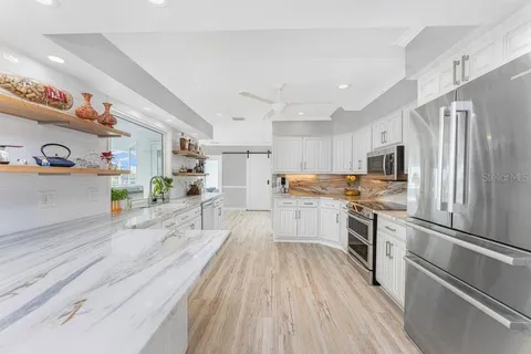 a kitchen with stainless steel appliances a stove sink microwave and cabinets