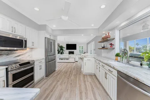 a kitchen with a table chairs refrigerator and cabinets