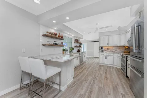 a view of a dining room and livingroom with furniture wooden floor a chandelier