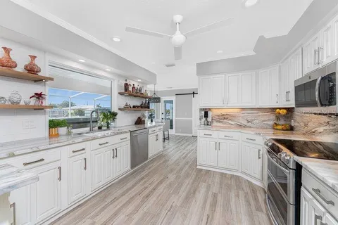 a view of a dining room and livingroom with furniture wooden floor a chandelier