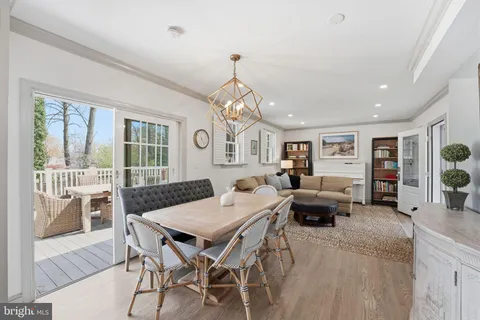 a living room with furniture a dining table and a chandelier