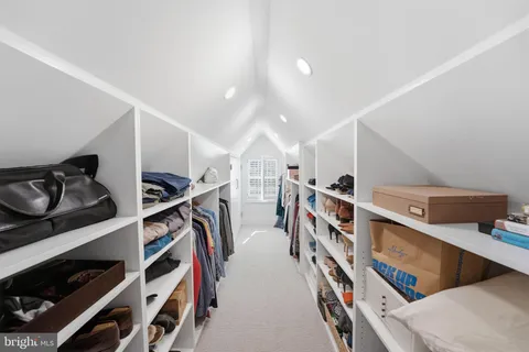 a view of walk in closet with clothes and shoes
