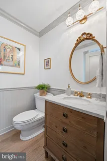 a bathroom with a granite countertop toilet a sink and a mirror