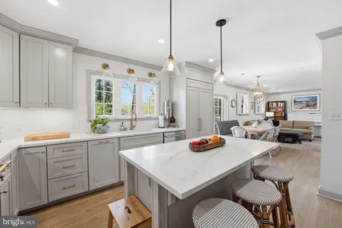 a kitchen with a sink a stove and chairs