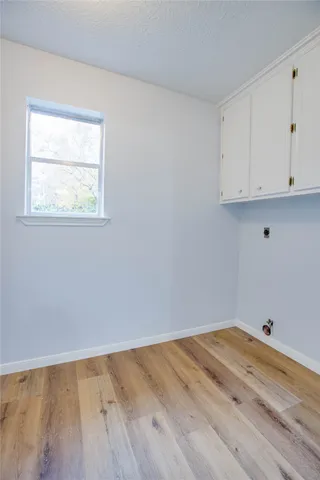 an empty room with wooden floor and window