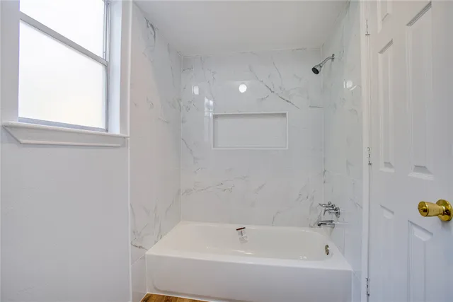 a bathroom with a bathtub and shower