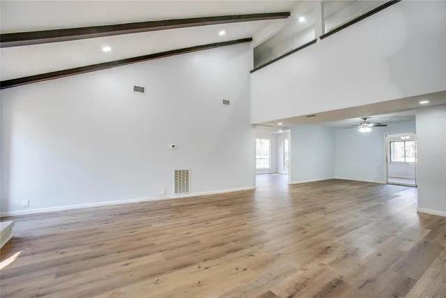a view of an empty room and wooden floor