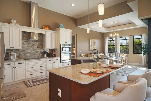 a kitchen with stainless steel appliances granite countertop a refrigerator and a stove top oven