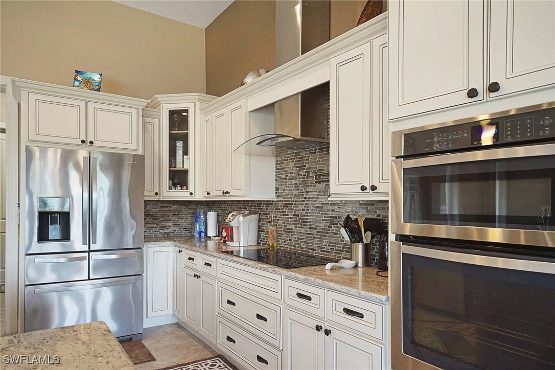 1502 Southwest 38th Street Cape Coral, FL 33914 - Photo 10 of 17 a kitchen with stainless steel appliances granite countertop a refrigerator and a stove top oven