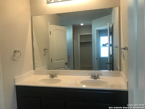 a bathroom with a double vanity sink and a mirror