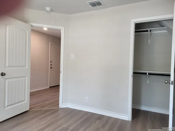 an empty room with wooden floor and closet