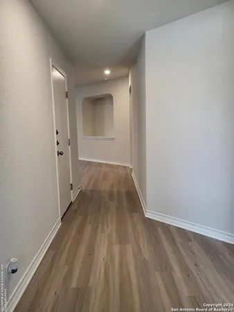 a view of a room with wooden floor and a hallway