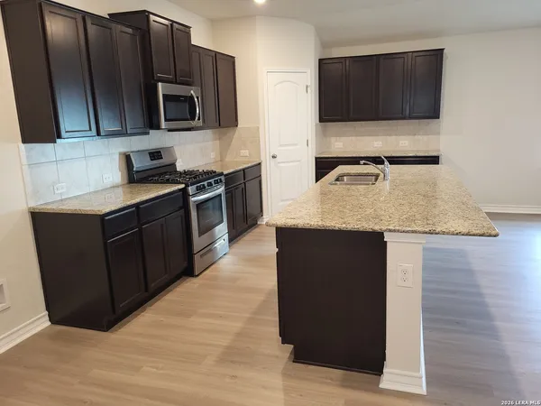 a kitchen with stainless steel appliances granite countertop a stove a microwave and a sink