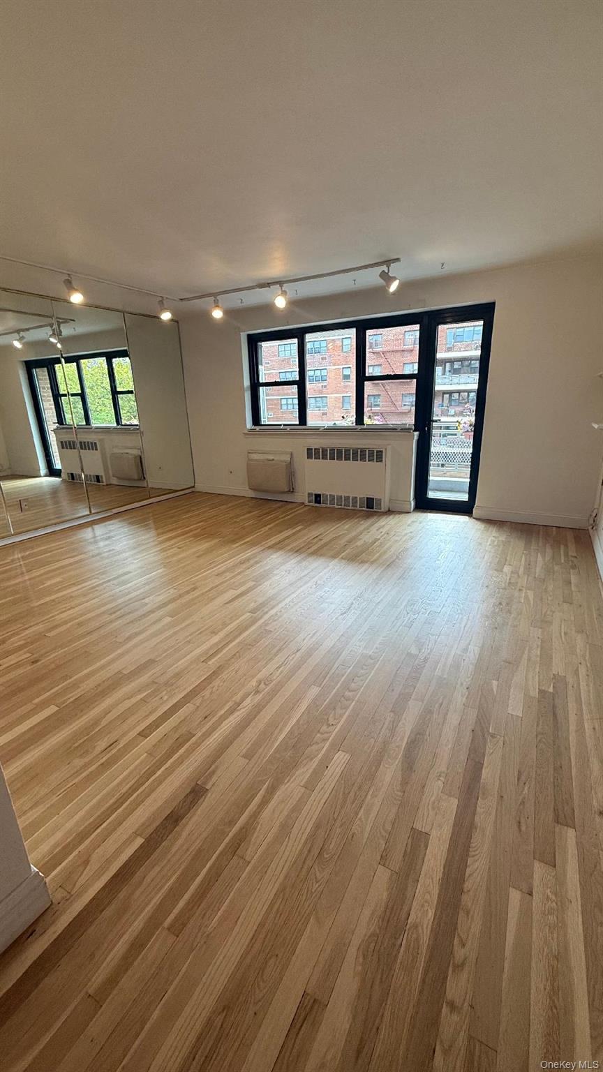 88-25 155th Avenue, Unit 4G Queens, NY 11414 - Photo 2 of 8 Spare room with rail lighting, healthy amount of natural light, and light wood-type flooring