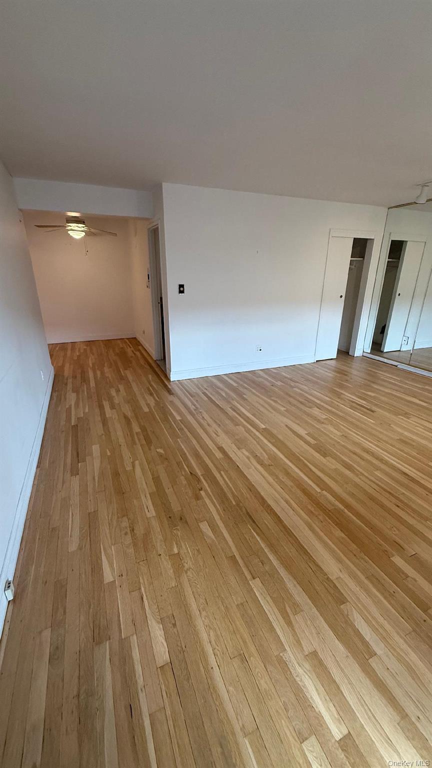 88-25 155th Avenue, Unit 4G Queens, NY 11414 - Photo 5 of 8 Spare room with light wood-style floors and a ceiling fan