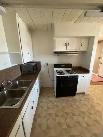 a kitchen with granite countertop a sink and cabinets