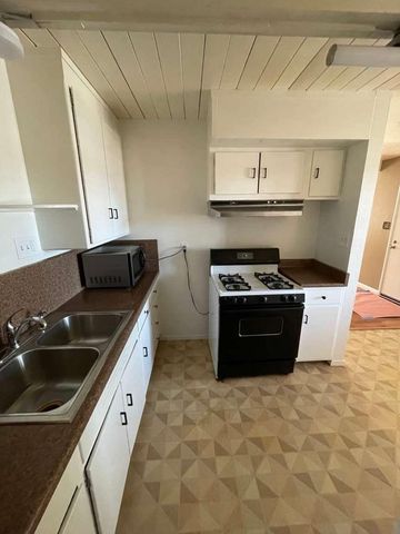 a kitchen with granite countertop a sink and cabinets