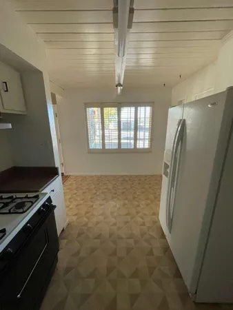 a view of a refrigerator in kitchen and window