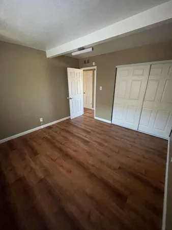 a view of an empty room with closet and a window