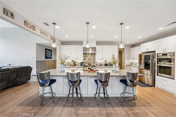 a large kitchen with stainless steel appliances lots of counter space and furniture