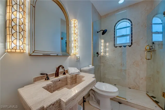 a bathroom with a sink and mirror with toilet