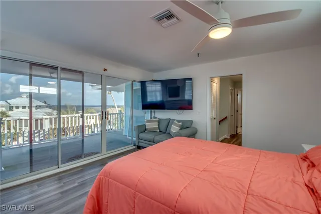 a bedroom with a large bed and a flat tv screen on dresser