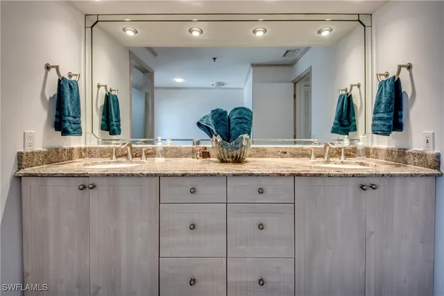 a bathroom with double sink and a mirror