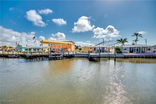 a view of a lake with a house swimming pool and outdoor seating