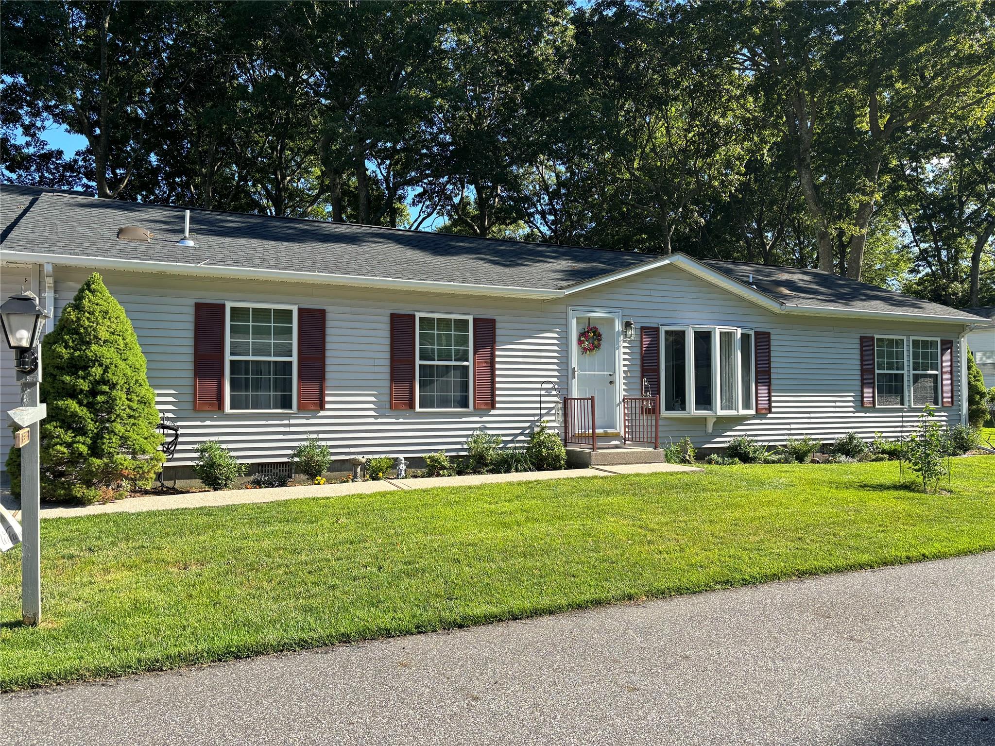1407 Middle Road, Unit 22 Calverton, NY 11933 - Photo 1 of 1 Single story home featuring a front lawn and roof with shingles