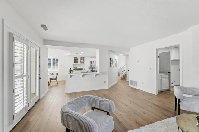 a view of a hallway with wooden floor and a potted plant
