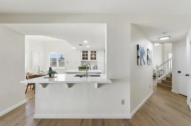 a bathroom with a granite countertop double vanity sink a mirror and a toilet