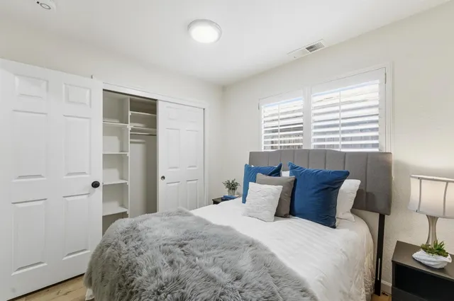 a bedroom with a bed and wooden floor