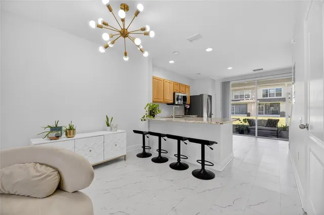 a kitchen with stainless steel appliances granite countertop a refrigerator oven a sink dishwasher and white cabinets with wooden floor