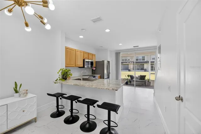 a kitchen with granite countertop a refrigerator stove and microwave