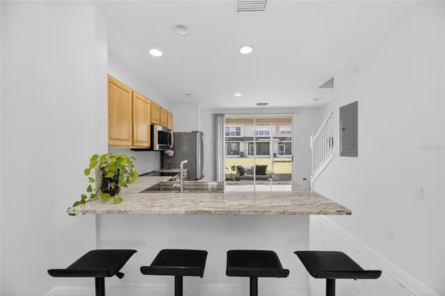 a kitchen with white cabinets and sink