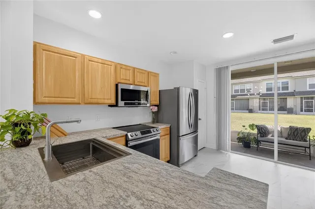 a large kitchen with stainless steel appliances granite countertop a stove and a refrigerator