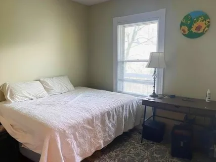 a bedroom with a bed and a window