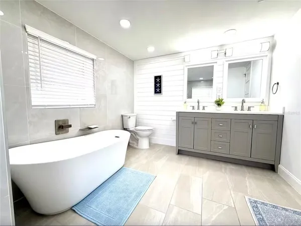 a large spacious bathroom with a large tub sink and mirror