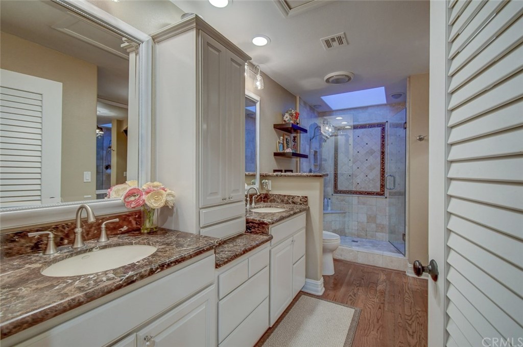 3901 Aruba Circle Huntington Beach, CA 92649 - Photo 16 of 56 a large bathroom with a granite countertop sink and a mirror